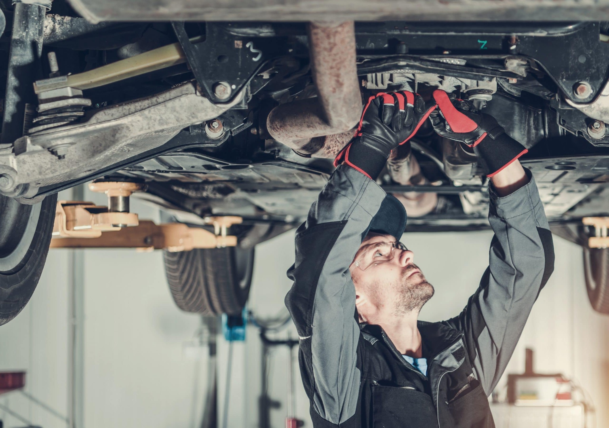 Illustrative stock photo of a technician inspecting a vehicle on a lift